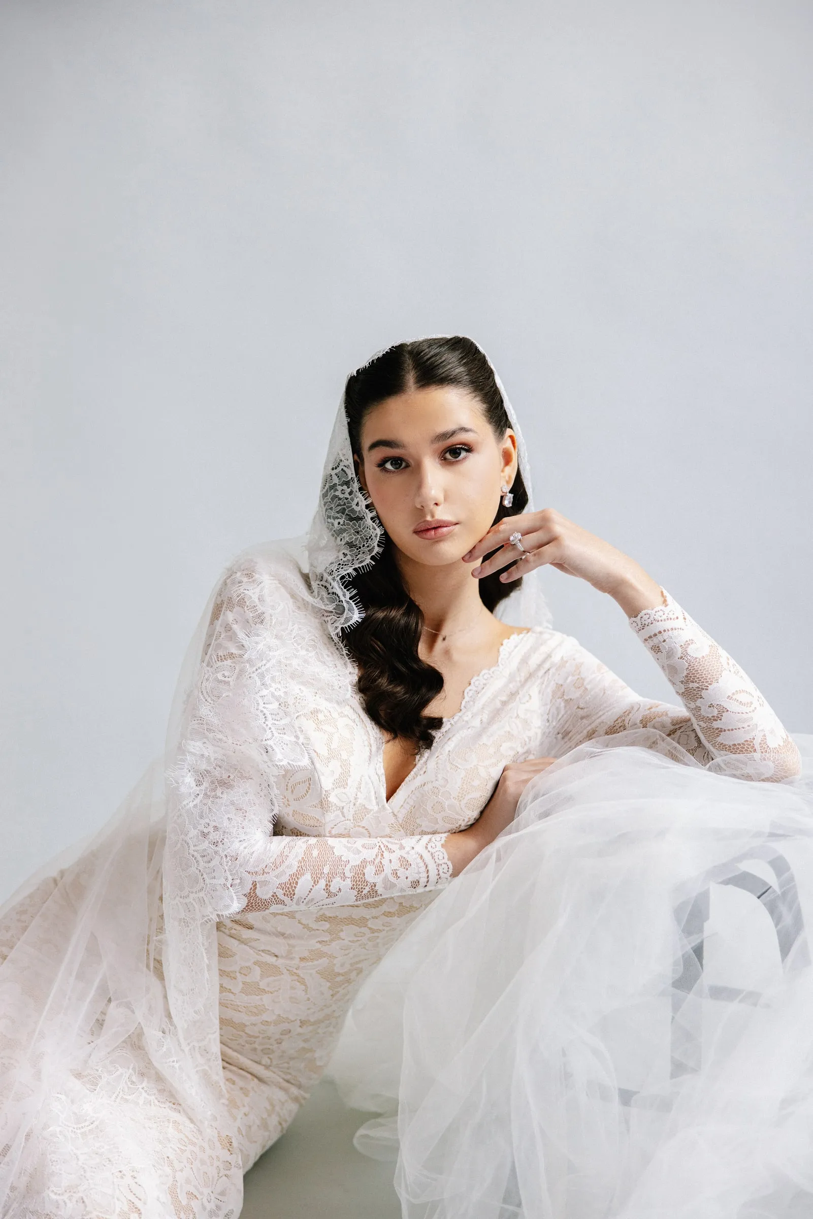 Studio bridal portrait in a lace mantilla with a clean matte base and a soft taupe eye.