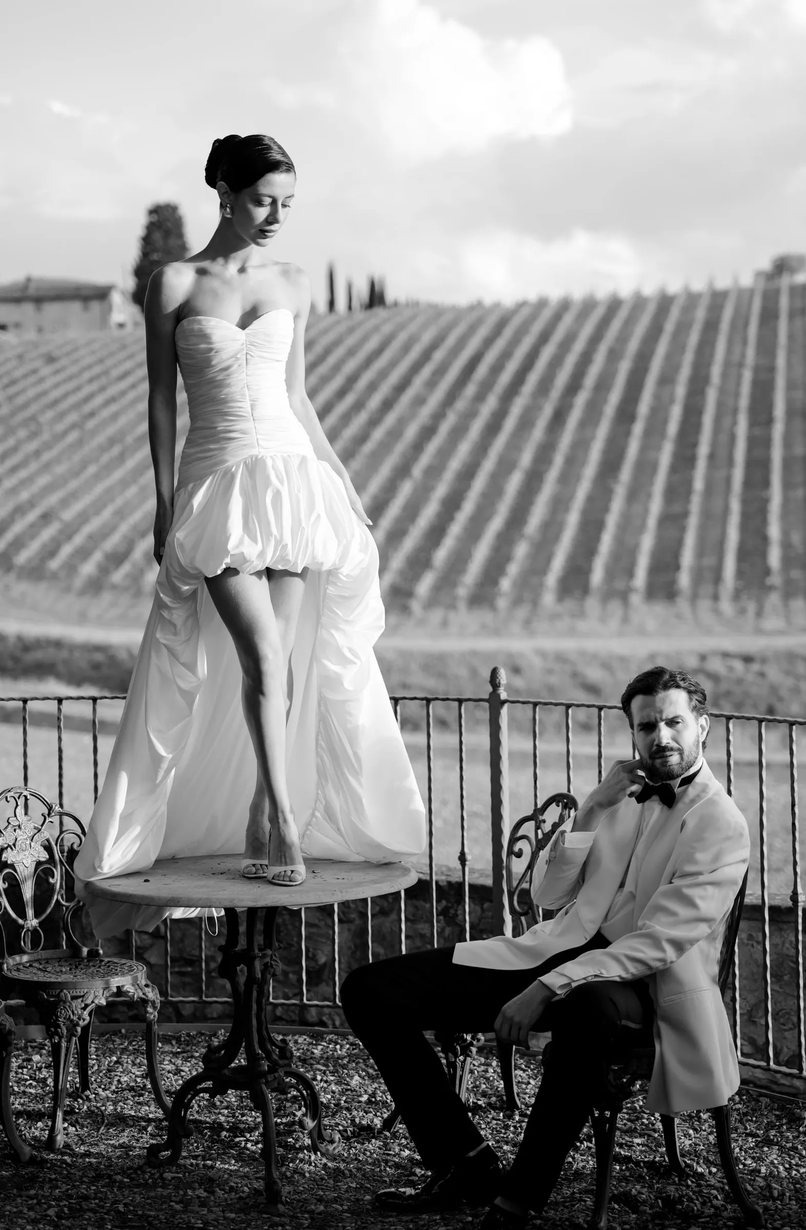 Black and white editorial portrait, matte skin and a strong defined brow, shot on location in a vineyard.